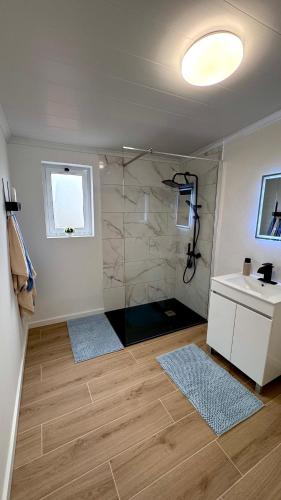 a bathroom with a shower with a sink and a mirror at Raiz Atlântica in Angra do Heroísmo