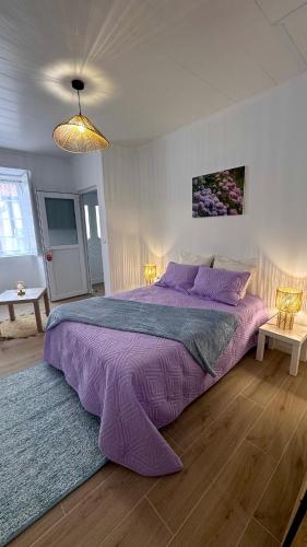 a bedroom with a large bed with purple sheets at Raiz Atlântica in Angra do Heroísmo