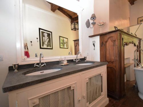 a bathroom with two sinks and a mirror at Castle near Agen with Shared Pool in Saint-Caprais-de-Lerm