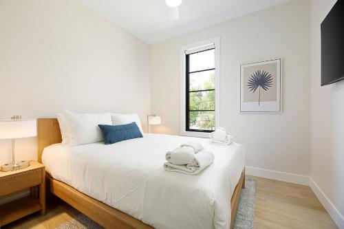 a white bedroom with a large bed with towels on it at Hamilton Place in Traverse City
