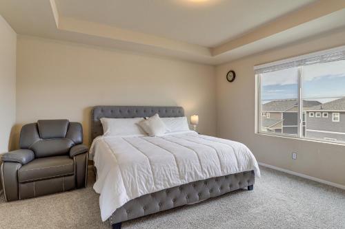 a bedroom with a bed and a chair and a window at 17 Mi to Downtown Denver Modern Aurora Home! in Aurora