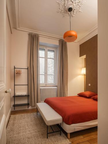 a bedroom with a red bed and a window at Le Dubedout - Hyper Centre - Bastille in Grenoble