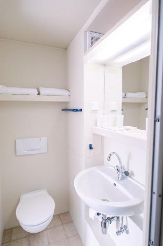 a white bathroom with a sink and a toilet at Hotel Spilburg in Wetzlar