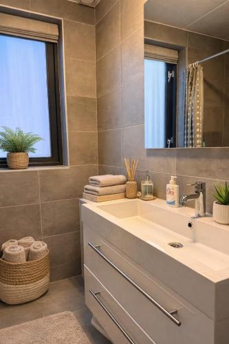 a bathroom with a sink and a mirror at CasaJos Rust en Comfort vlakbij Nijmegen in Ewijk