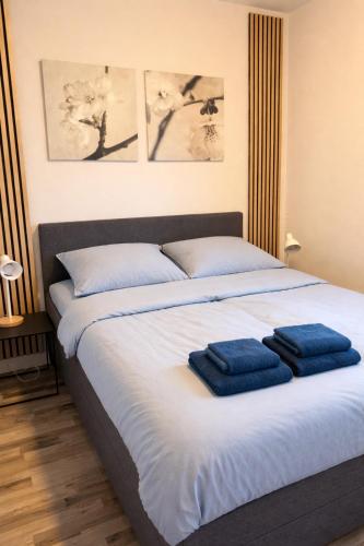 a bedroom with a bed with two blue towels on it at CasaJos Rust en Comfort vlakbij Nijmegen in Ewijk
