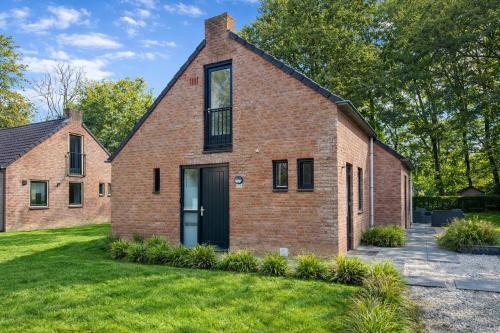 a brick house with a black door at CasaJos Rust en Comfort vlakbij Nijmegen in Ewijk