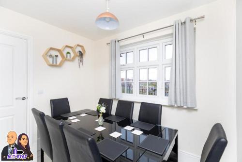 a dining room with a black table and black chairs at Kirkstall by Alt-Stay Contractor Accommodation - 4 Bed Contractor Home With Parking, Wi-Fi & Full Kitchen - Ideal For Long stays in Wakefield