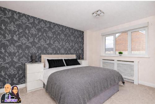 a bedroom with a bed and a black and white wall at Kirkstall by Alt-Stay Contractor Accommodation - 4 Bed Contractor Home With Parking, Wi-Fi & Full Kitchen - Ideal For Long stays in Wakefield