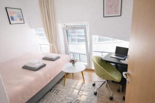 a bedroom with a bed and a desk with a laptop at Apartman Lori M sa parkingom in Kraljevo
