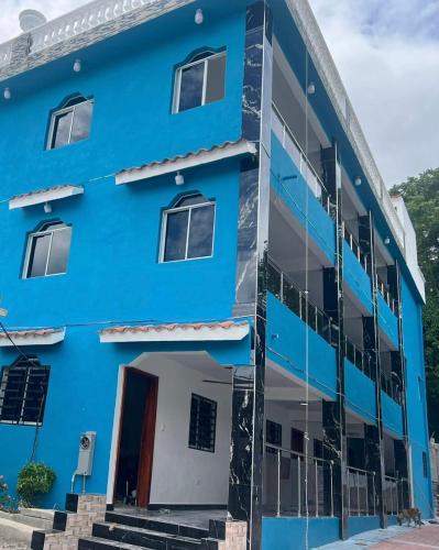 a blue building with a front door and stairs at Brisas del mar in Santa Cruz de Barahona