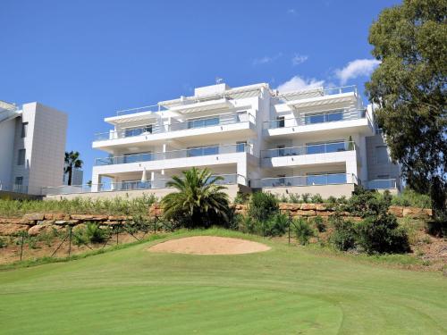 a large white building with a putting green at Belvilla by OYO Miraval in Sitio de Calahonda