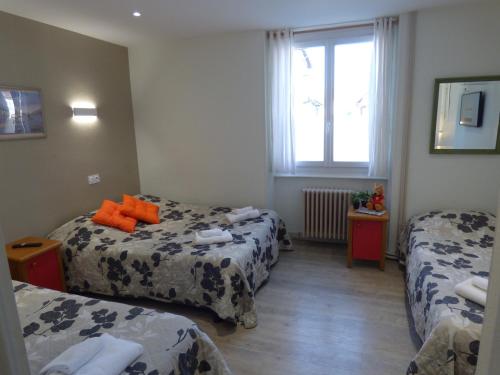 a hotel room with two beds and a window at Auberge des Avenières in Les Avenières
