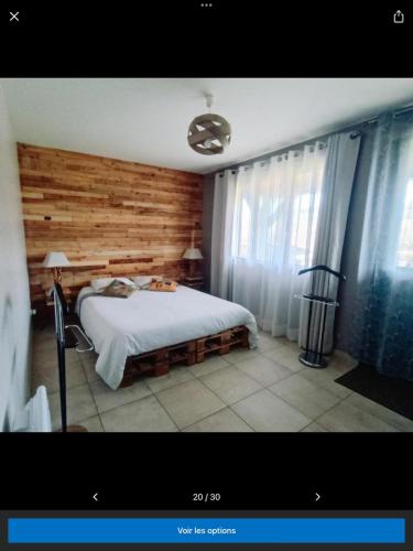 a bedroom with a bed and a wooden wall at Le petit Flotteur in Chevroches