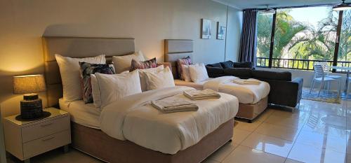 a bedroom with a large bed and a couch at Breakers Resort Apartment 314 in Durban