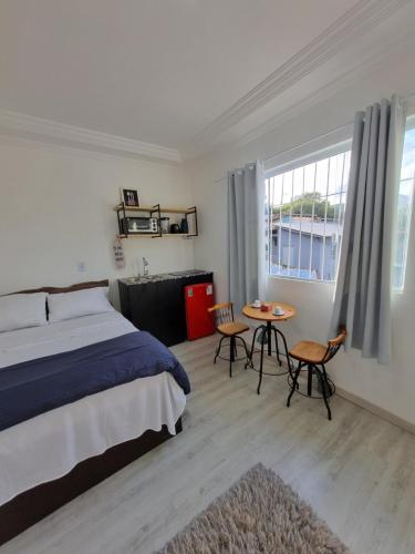 a bedroom with a bed and a table and chairs at Suíte Garden em Butantã Próximo á USP - Self Check-in in São Paulo