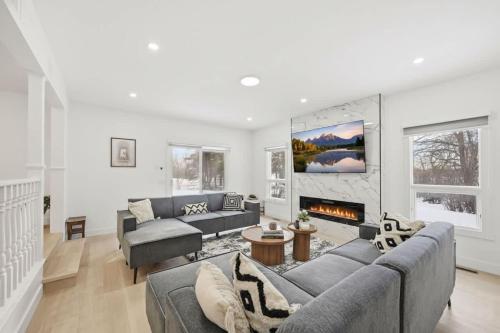 a living room with two couches and a fireplace at Executive Acreage 3 King Beds Fireplace AC in Airdrie