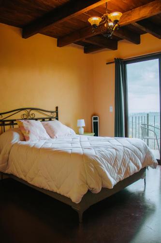 a bedroom with a bed and a large window at La Magia del Bosque in Puebla