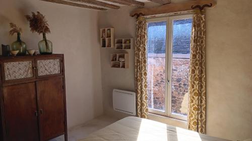 La maison jaune في سان سوفور - ان - بيساي: غرفة نوم بها سرير ونافذة كبيرة