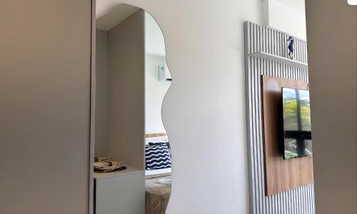 a hallway with a mirror next to a door at Maré Alta Beach Hall by AFT in Tamandaré