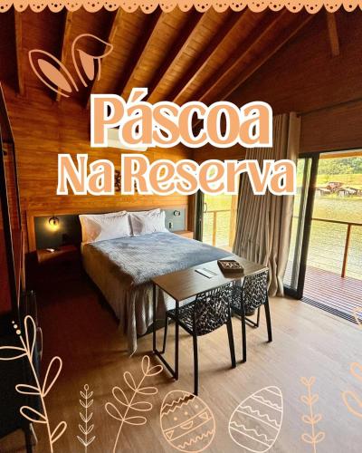a bedroom with a bed and a table in a room at Pousada reserva do J in Serra Negra