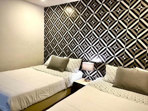 a bedroom with two beds and a geometric wall at LÁZARO D primer piso in Monterrey