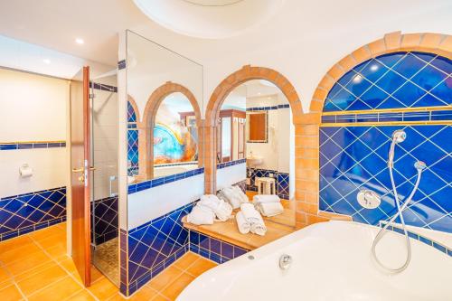 a bathroom with blue tiled walls and a tub at Bavaria Lifestyle Hotel mit Klimaanlage in Altötting