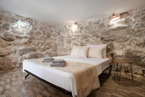 a bedroom with a bed and a stone wall at Holiday house with heated pool in Neorić