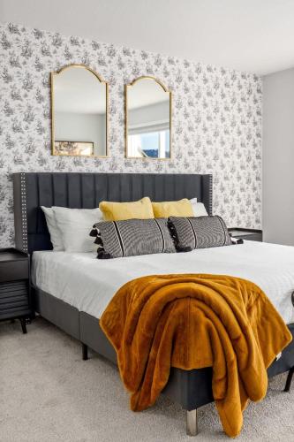 a bedroom with a large bed with two mirrors at Arcade King Bed Espresso Maker Family Friendly in Airdrie