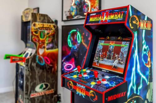 a video game arcade machine in a room with other games at Arcade King Bed Espresso Maker Family Friendly in Airdrie