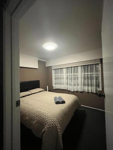 a bedroom with a bed and a window at B&B on Station in Paeroa