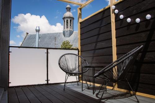 a chair sitting on a deck with a lighthouse in the background at Loft 15 in Alkmaar