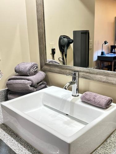 a white sink in a bathroom with a mirror at Hotel Boutique Querencia in Tijuana