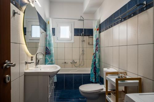a bathroom with a sink and a toilet and a tub at Ioana Sea View in Corfu
