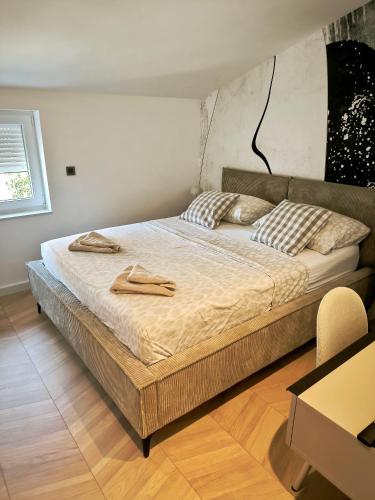 a bed in a bedroom with two towels on it at Artistik in Vodice