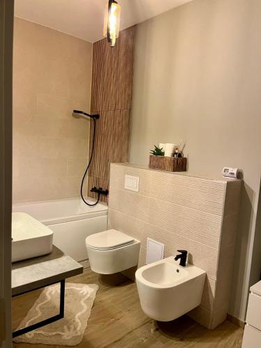 a bathroom with a white toilet and a sink at Del House in Zărneşti