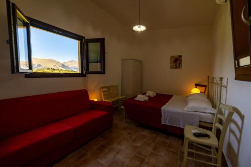 a room with a bed and a couch and a window at Casa Priora vista Sibillini in Montefortino