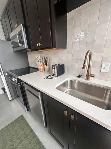 a kitchen with a sink and a microwave at Gilded Skyline, Walk Everywhere, 7th-Floor Views in Chattanooga