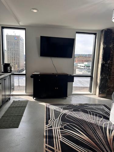 a living room with a flat screen tv on the wall at Gilded Skyline, Walk Everywhere, 7th-Floor Views in Chattanooga