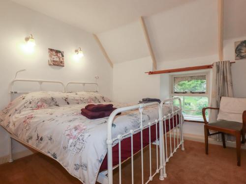 a bedroom with a bed and a chair and a window at Plenteth in Truro