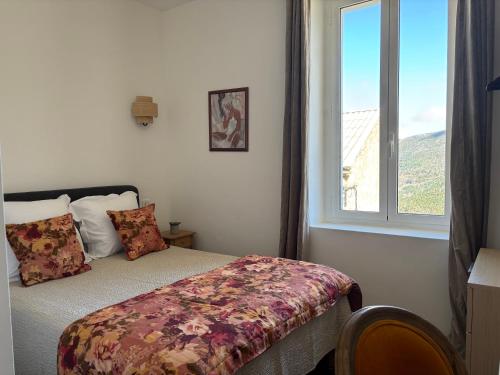 a bedroom with a bed and a window at Hotel U Campanile in Vivario