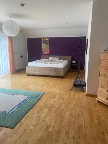 a bedroom with a bed and a purple wall at Ferienwohnung Lenzen in Kall