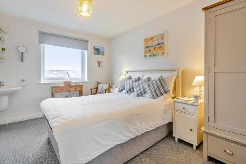 a bedroom with a large white bed and a sink at 3 Bed in Abersoch oc-c33667 in Abersoch
