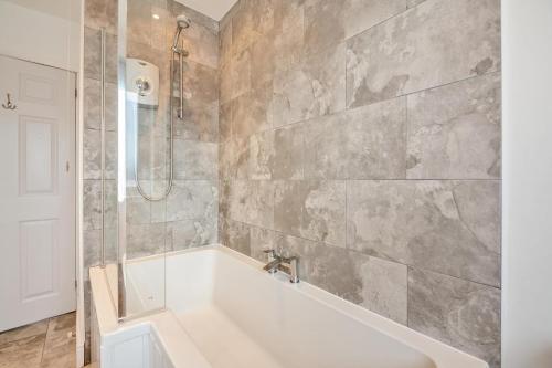 a bathroom with a bath tub and a shower at 3 Bed in Abersoch oc-c33667 in Abersoch