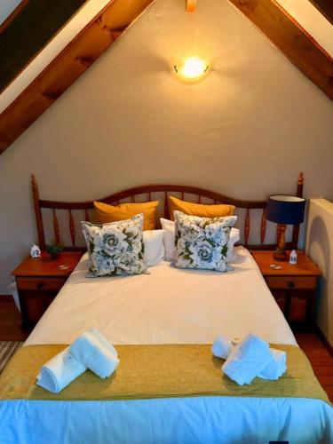 a bedroom with a large bed with blue and orange pillows at Forest Hill Accomodation in Port Alfred
