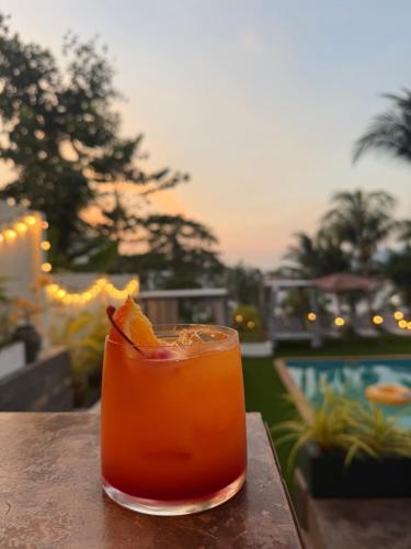 a drink sitting on a table next to a pool at Sea Hills Resort in Patong Beach