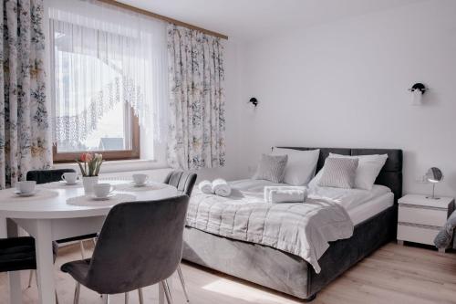 a bedroom with a bed and a table and a dining room at Apartamenty Pienińska Aura in Czorsztyn