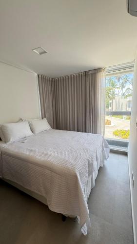 a bedroom with a bed and a large window at Casa Marimar Milagres- Praia do Marceneiro in Passo de Camarajibe