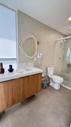a bathroom with a sink and a toilet and a mirror at Casa Marimar Milagres- Praia do Marceneiro in Passo de Camarajibe