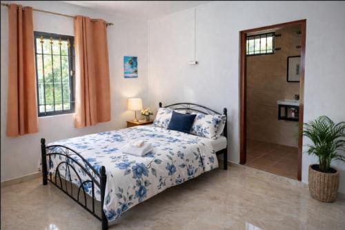 a bedroom with a bed with blue and white sheets at D'eaU BleU Villa-Private pool in Pereybere