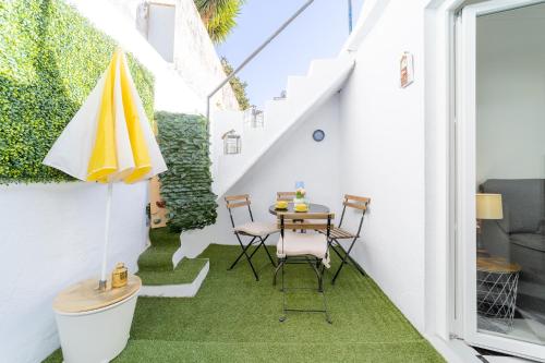 a small patio with a table and chairs on a balcony at Charming 4-bedroom House with terrace in Lisbon